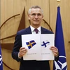 Tổng Thư ký NATO Jens Stoltenberg cùng đơn xin gia nhập NATO của Phần Lan và Thụy Điển. (Ảnh: AFP/TTXVN)