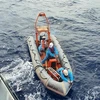 Nhân viên tàu SAR 412 dùng canô tiếp cận tàu cá ứng cứu một thuyền viên gặp nạn. (Ảnh: TTXVN phát)