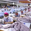 Một dây chuyền may gia công sản phẩm quần áo bảo hộ lao động và áo sơ mi xuất khẩu. (Ảnh: Vũ Sinh/TTXVN)