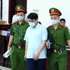 Lực lượng chức năng dẫn giải bị cáo Nguyễn Đức Chung (cựu Chủ tịch Ủy ban Nhân dân thành phố Hà Nội) tới phiên tòa. (Ảnh: Phạm Kiên/TTXVN)