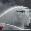 Tàu và máy bay của lực lượng cứu hỏa Mexico tham gia dập các đám cháy taị kho dầu lớn bên Vịnh Matanzas, Cuba. (Ảnh: AFP/TTXVN)