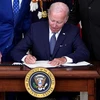 Tổng thống Mỹ Joe Biden ký một văn kiện tại Nhà Trắng ở Washington, DC. (Ảnh: AFP/TTXVN)