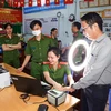 Cán bộ Công an phường Tân An, quận Ninh Kiều hướng dẫn người dân thực hiện đăng ký tài khoản định danh điện tử mức độ 2. (Ảnh: TTXVN phát)