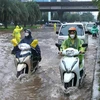 Các phương tiện đi lại khó khăn trong điều kiện ngập lụt do mua lớn. (Ảnh: Hoàng Hiếu/TTXVN)