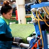 Công nhân làm việc trong một công ty sản xuất thảm cỏ nhân tạo ở Khu công nghiệp Phước Đông. (Ảnh: Hồng Đạt/TTXVN)