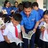 Bí thư Tỉnh đoàn Long An Trần Hải Phú với học sinh Trường tiểu học Nhơn Hòa tại buổi trao tặng Tủ sách Đinh Hữu Dư. (Ảnh: Đức Hạnh/TTXVN)