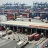 Xe chở container ra vào Tân Cảng Cát Lái. (Ảnh: Hồng Đạt/TTXVN)