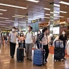 Khách du lịch đeo khẩu trang để phòng tránh lây nhiễm virus corona tại sân bay quốc tế Changi, Singapore. (Ảnh: AFP/TTXVN)