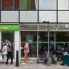 Người dân xếp hàng bên ngoài một trung tâm giới thiệu việc làm ở London, Anh. (Ảnh: AFP/TTXVN)