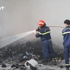 Lực lượng cứu hỏa đag dập tắt đám cháy. (Ảnh: P.V/Vietnam+)