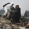 Lực lượng cứu hộ chuyển nạn nhân bị thương ra khỏi đống đổ nát sau trận động đất tại Afrin, tỉnh Aleppo (Syria). (Ảnh: AFP/TTXVN)