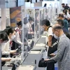 Hành khách làm thủ tục tại sân bay Haneda ở Tokyo, Nhật Bản. (Ảnh: Kyodo/TTXVN)
