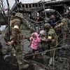 Người dân sơ tán khỏi thành phố Irpin, Tây Bắc thủ đô Kiev, Ukraine. (Ảnh: AFP/TTXVN)