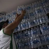 Người dân mua nước đóng chai. (Ảnh: AFP/TTXVN)