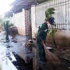 Công nhân của Công ty cổ phần đường Biên Hòa-Phan Rang phun nước xử lý ô nhiễm do bụi tro cho người dân. (Ảnh: Công Thử/TTXVN)