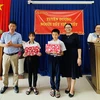 Phó giám đốc Sở Giáo dục và Đào tạo Đồng Nai Đỗ Đăng Bảo Linh trao giấy khen cho em Lê Nhã Trâm và Nguyễn Quốc Kỳ. (Nguồn: Báo Đồng Nai)