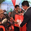 Đại diện người gốc Việt có hoàn cảnh khó khăn tại tỉnh Siem Reap nhận phần quà. (Ảnh: Hoàng Minh/TTXVN)