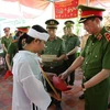 Trung tướng Nguyễn Duy Ngọc, Thứ trưởng Bộ Công an, trao quyết định của Bộ trưởng Bộ Công an về việc truy thăng cấp bậc hàm từ Thiếu tá lên Trung tá đối với chiến sỹ Nguyễn Xuân Hào. (Ảnh: TTXVN phát)