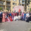 Bà con cộng đồng cùng các vị khách mời Hungary chụp ảnh kỷ niệm bên tượng Bác. (Ảnh: Hoàng Linh/Vietnam+)