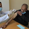 Nhân viên y tế tiêm vaccine ngừa COVID-19 cho người dân Palestine tại Dải Gaza. (Ảnh: THX/TTXVN)