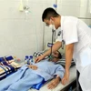 Bệnh nhân Hoàng Văn Sơn mắc bệnh bụi phổi sau một thời gian làm việc tại Công ty trách nhiệm hữu hạn Châu Tiến đang điều trị tại Bệnh viện Phổi Nghệ An. (Ảnh: Tá Chuyên/TTXVN)