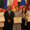 Các cá nhân được tặng giấy khen chụp ảnh lưu niệm cùng đại diện Đại sứ quán Việt Nam tại Cộng hòa Séc. (Ảnh: Ngọc Biên/TTXVN)