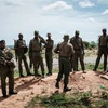 Lực lượng an ninh gác tại lối vào rừng Shakahola, gần thị trấn Malindi, Kenya, nơi hàng chục thi thể các tín đồ của một giáo phái được khai quật. (Ảnh: AFP/TTXVN)