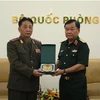 Thượng tướng Hoàng Xuân Chiến trao quà lưu niệm tặng Đại tá Kim Myong Chol. (Ảnh: Hồng Pha/TTXVN phát)