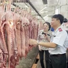 Đoàn kiểm tra Ban Quản lý An toàn Thực phẩm Thành phố Hồ Chí Minh kiểm tra thịt lợn nhập về Chợ đầu mối Nông sản Thực phẩm Hóc Môn. (Ảnh: TTXVN phát)