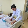Bác sỹ Phan Văn Tú, Khoa Chấn thương Chỉnh hình, Bệnh viện Bà Rịa, thăm khám cho bệnh nhân T.T.N.Q sau ca phẫu thuật. (Ảnh: Hoàng Nhị/TTXVN)
