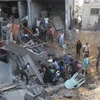 Người dân tìm kiếm người bị mắc kẹt trong những đống đổ nát sau vụ không kích của Israel tại Khan Younis, Dải Gaza. (Ảnh: THX/TTXVN)
