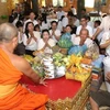 Người dân Campuchia thực hiện nghi thức cúng dường chư tăng tại tại Chùa Svay Romeat tỉnh Siem Reap. (Ảnh: AKP/TTXVN)