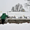 Người dân thu dọn tuyết tại một nghĩa trang ở Kiev, Ukraine. (Ảnh: AFP/TTXVN)