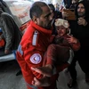 Chuyển một em nhỏ bị thương sau cuộc oanh kích của Israel tới bệnh viện ở Dải Gaza. (Ảnh: THX/TTXVN)