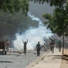 Người biểu tình quá khích ném đá về phía cảnh sát tại Dakar, Senegal, ngày 1/6/2023. (Ảnh: AFP/TTXVN)