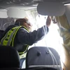 Điều tra viên kiểm tra phần cửa sổ bị bung ra của máy bay Boeing 737 MAX 9 thuộc hãng hàng không Alaska Airlines, tại Portland, Oregon, Mỹ, ngày 7/1. (Ảnh: AFP/TTXVN)