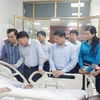 Thăm hỏi bệnh nhân Hoa Văn Sang (sinh năm 2002) đang được theo dõi tại Bệnh viện Đa khoa tỉnh Quảng Ninh. (Ảnh: Thanh Vân/TTXVN)