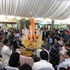 Các đại biểu thực hiện nghi lễ truyền thống của Lào. (Ảnh: TTXVN phát)