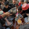 Người dân chờ nhận lương thực viện trợ ở thành phố Rafah, phía Nam Dải Gaza. (Ảnh: THX/TTXVN)