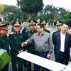 Thủ tướng Phạm Minh Chính trao đổi về sản phẩm công nghệ cao của Tập đoàn Viettel. (Ảnh: Dương Giang/TTXVN)
