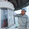 Công nhân Công ty đảm bảo an toàn hàng hải Biển Đông và Hải đảo (Tổng Công ty bảo đảm an toàn hàng hải miền Nam) Nguyễn Minh Thắng bảo dưỡng đèn hải đăng trên đảo An Bang. (Ảnh: Hoàng Hiếu/TTXVN)
