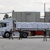 Lực lượng an ninh Israel kiểm tra xe chở hàng nhân đạo vào Dải Gaza qua cửa khẩu Kerem Shalom. (Ảnh: AFP/TTXVN)