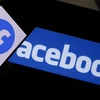Biểu tượng Facebook trên màn hình điện thoại và máy tính. (Ảnh: AFP/TTXVN)
