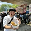 Một thanh niên Nhật Bản vui mừng khi mua được một tô phở mà anh nói rằng đúng hương vị phở Hà Nội. (Ảnh: Phạm Tuân/Vietnam+)