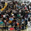 Hành khách xếp hàng tại quầy làm tủ tục tại sân bay quốc tế Ninoy Aquino ở Manila, Philippines. (Ảnh: AFP/TTXVN)