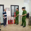 Cán bộ, chiến sỹ Công an phường Trung Hòa, quận Cầu Giấy kiểm tra, hướng dẫn trang thiết bị phòng cháy chữa cháy cho chủ cơ sở kinh doanh nhà trọ, chung cư mini. (Ảnh: Phạm Kiên/TTXVN)