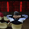 Nhà đầu tư theo dõi tại Sàn chứng khoán Thượng Hải. (Ảnh: AFP/TTXVN)