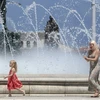 Người dân tránh nóng bên vòi phun nước tại Skopje, Bắc Macedonia. (Ảnh: AFP/TTXVN)