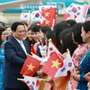 Cộng đồng người Việt Nam tại Hàn Quốc chào đón Thủ tướng Phạm Minh Chính và Phu nhân. (Ảnh: Dương Giang/TTXVN)