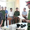 Ông Nguyễn Thái Hưng (ngoài cùng bên trái) nghe Cơ quan Cảnh sát Điều tra tống đạt các quyết định. (Ảnh: TTXVN phát)